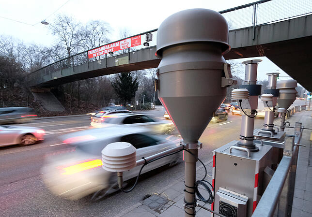 Autos fahren an der Feinstaub-Messstation am Neckartor vorbei.