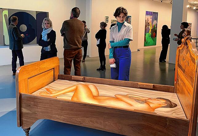Eine Besucherin betrachtet das nackte Selbstbildnis von Jan-Hendrik Pelz im Bettgestell. Passanten des Singener Kunstmuseums können es ...