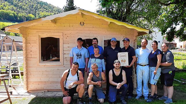 Die Helfer der Feuerwehrabteilung Hänner mit der glücklichen Familie O. im Ahrtal vor dem neu errichteten Gartenhaus der Flutopfer. ...