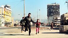 Bilder aus dem Krieg: Ein Einwohner in Sarajevo flüchtet mit einem kleinen Jungen an der Hand vor den Schüssen. Das Foto entstand im ...