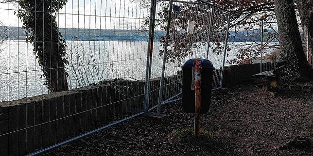 Wer hier verweilt, blickt durch ein Gitter: Zäune stehen links und rechts von einer Bank in der Nähe der Schmugglerbucht.