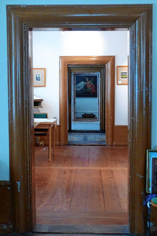Ein architektonisch außergewöhnliches Bild. Es ist der Blick durch vier Türen der fünf hintereinanderliegenden Zimmer.