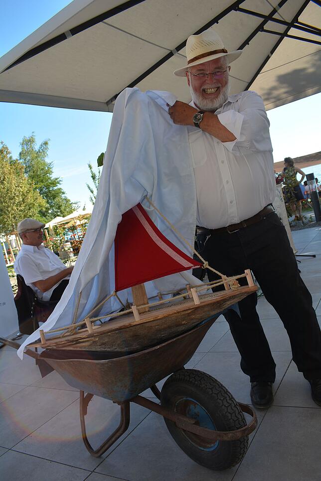 Manfred Weiss, ein Freund des Hauses, überreicht als Eröffnungsgeschenk ein Segelboot namens &bdquo;Haltnau&ldquo;.