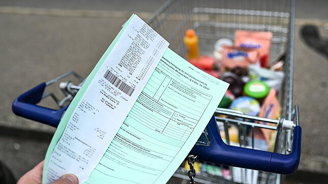 ILLUSTRATION: Ein Kunde hält einen Ausfuhrschein samt Rechnung vor den Einkaufswagen. (zu dpa: “Offene Grenzen locken Schweizer wieder ...