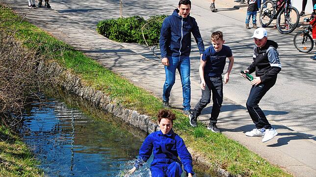 Julian Kalinasch springt zum ersten Mal in den Dorfbach. Die beiden Begleiter Nico Albicker und Silas Hossmann sorgten dafür, dass der ...