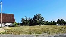 Auf dieser Fläche sollen künftig Ein- und Mehrfamilienhäuser entstehen. Das Bauernhaus links gehört mit zum Bebauungsplan „Baint“