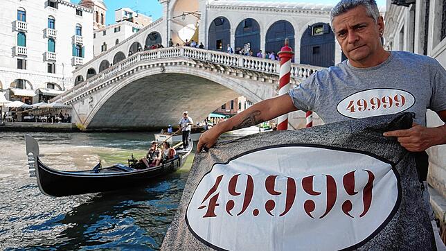 Eine schöne Stadt ist bedroht: Matteo Secchi mit einem Protestplaket vor der berühmten Rialto-Brücke.