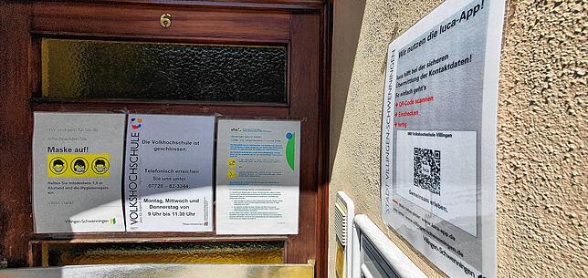 Schilder am Eingang der Volkshochschule in Villingen erklären die Corona-Regeln.