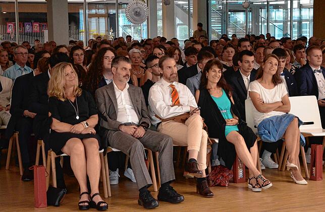 Lehrer und Eltern verfolgen die Reden bei der Abschlussfeier des Gymnasiums.