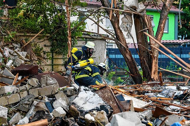 Feuerwehrleute in den Trümmern des zerstörten Hauses.