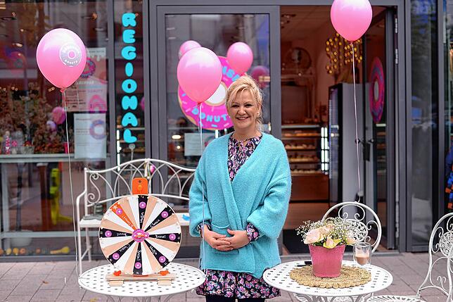 Demet Beydilli lockt mit einem Glücksrad Neugierige an. Zu gewinnen gibt es Donuts und Muffins.