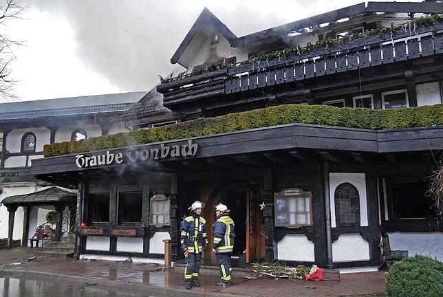 Einsatzkräfte der Feuerwehr stehen vor dem Altbau des Restaurants im Hotel “Traube Tonbach„.
