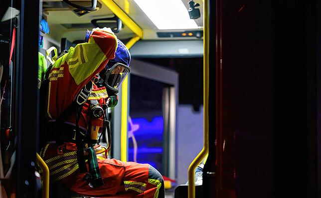 Ein ehrenamtlicher Feuerwehrmann rüstet sich im Löschfahrzeug in Lüneburg in der Silvesternacht ab.