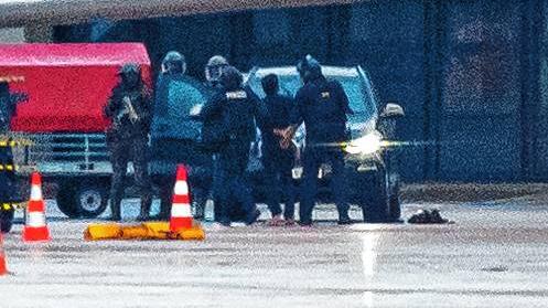 Der Geiselnehmer wird auf dem Flughafen von der Polizei weggeführt. Der bewaffnete Mann, der am Samstagabend mit seinem Auto und seinem ...