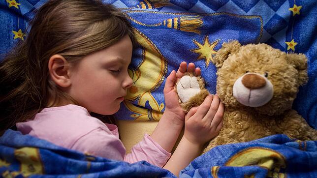 Egal ob mit Teddy oder ohne: Der Schlafbedarf von Kindern ändert sich je nach Alter drastisch.