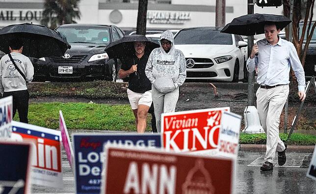 Wähler trotzen in Houston dem strömenden Regen, um im Wahllokal ihre Stimme abzugeben.
