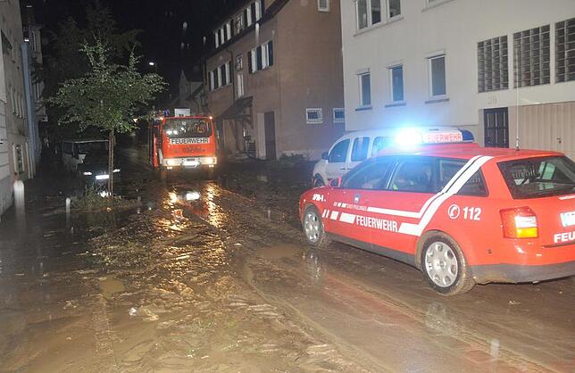 Parkhaus nach Starkregen überschwemmt Feuerwehrkräfte versuchen nach einem Starkregen in Pfullingen (Baden-Württemberg) eine überschwemmte und verschlammte Straße zu reinigen.