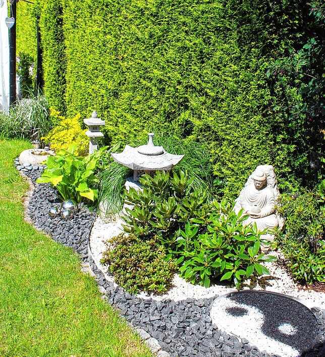 Das Symbol im Vordergrund, Yin und Yang, ist aus weißem und schwarzem Kies gelegt.