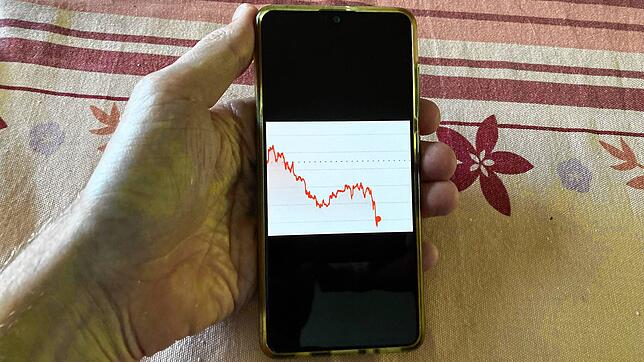 Eine Person beobachtet den Kurs einer Krypto-Währung auf dem Smartphone (Symbolbild).