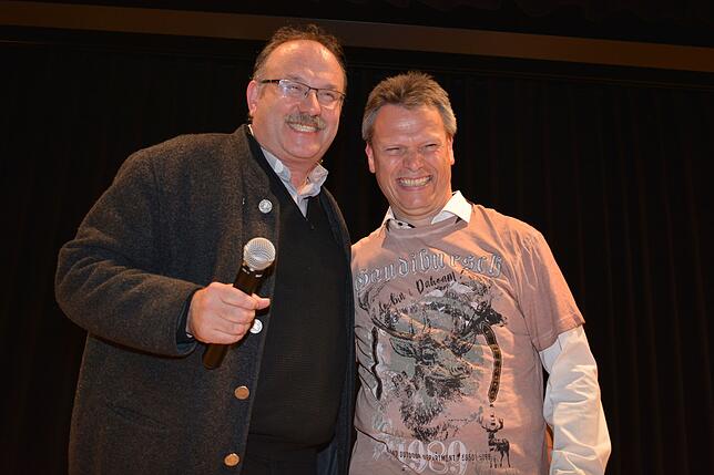 Der katholische Stadtpfarrer Matthias Schneider (links) schenkt Frank zum Jubiläum ein &bdquo;Gaudibursch&ldquo;-T-Shirt.