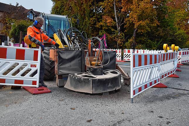 Ein Mitarbeiter der Firma Peter Gross Bau fräst hier einen großen Gullideckel aus.