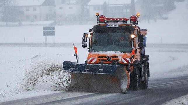 Ein Fahrzeug des Winterdienst räumt Schnee auf einer Straße bei Engstingen auf der Schwäbischen Alb.
