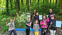 Kinder und Förster präsentieren ihre kreativen Werke aus dem Workshop „Kunst im Wald“. Foto: Melanie Schweizer