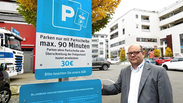 Matthias Schopf, Pressesprecher von Edeka Sulger, an einem der Schilder, die auf die neue Parksituation aufmerksam machen.
