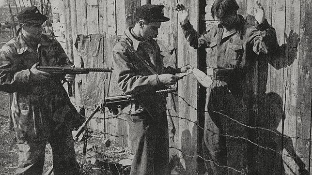 Soldaten kontrollieren 1944 in Slowenien  einen Partisanen (r.). Bild: Luce Mantovan/Bibliothek DeAgostini/Getty Images