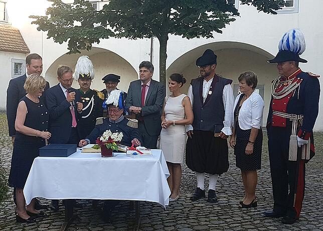Hoher Gast: Hans-Joachim Böhm, Landeskommandant der Bürgerwehren und Milizen Baden-Südhessen und Festredner beim Heimatabend, trägt sich ...