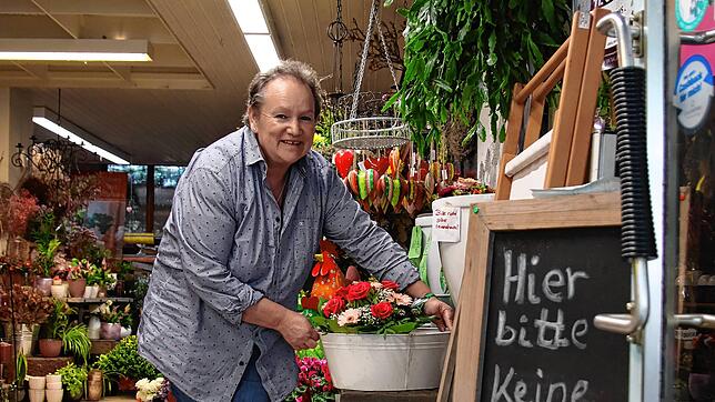 Ulrike Stöckle am Eingang ihres Blumengeschäfts. Der gusseiserne Stuhl ist verschwunden, der dazugehörige Tisch (rechts neben ihr) noch da.