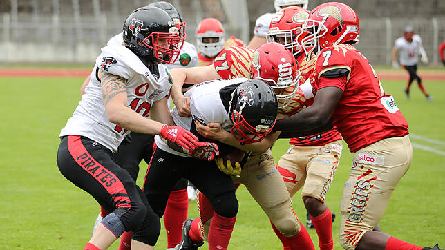 Der Runningback der Konstanz Pirates, Moritz Katzer (mit Ball, gelbe Handschuhe) kämpft sich zum Raumgewinn durch die Defensive der ...
