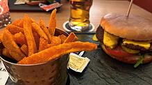 Mexikanisch belegter Burger mit Guacamole und Rucola mit Süßkartoffelpommes ist an diesem Tag ein Menü der Mittagskarte im Café Walker.