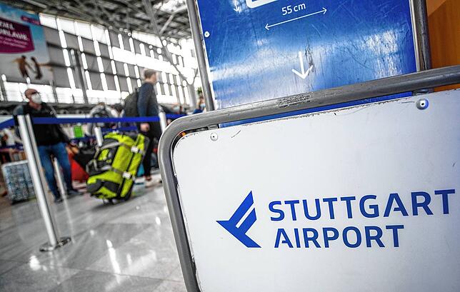 Fluggäste gehen zu Beginn der Herbstferien in Baden-Württemberg mit ihrem Gepäck zu Check-In-Schaltern am Flughafen Stuttgart.