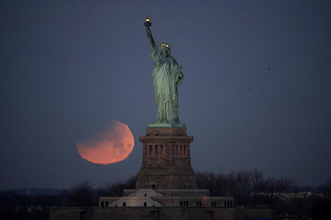 31.01.2018, USA, New York: Ein Supermond steht hinter der Freiheitsstatue am Himmel. Foto: Julio Cortez/AP/dpa +++ dpa-Bildfunk +++
