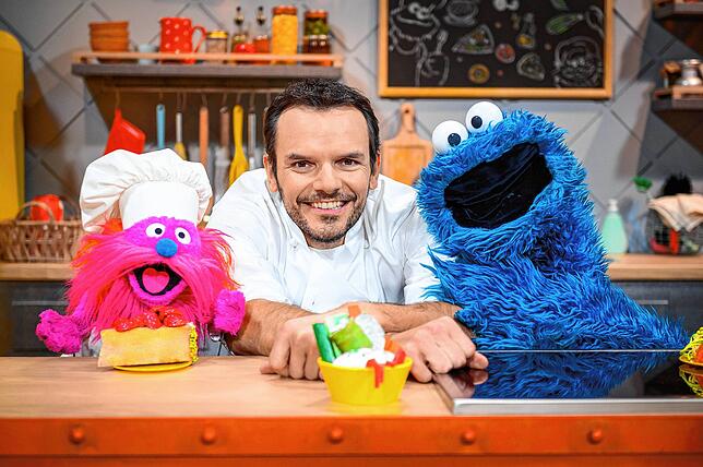 Fernsehkoch Steffen Henssler zwischen den Puppen “Gonger„ (l) und “Krümelmonster„ am Film-Set. RTL+, SUPER RTL ...
