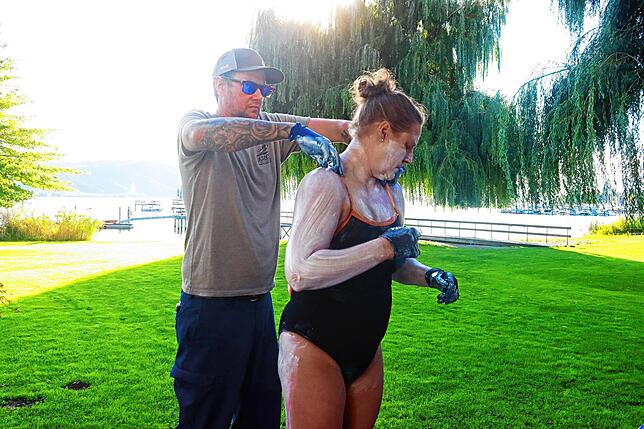 Sarah Thomas und ihr Mann Ryan bereiten sich auf die Bodensee-Längsquerung im Freibad Bodman vor. Die Marathon-Schwimmerin cremt sich ...