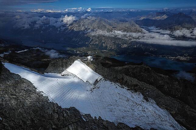 Blick auf den Corvatsch-Gletscher, während Mitarbeiter der Bergbahnen Gletscher-Schutzvlies entfernen. Das Schweizerische ...