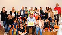 Kinder und Erzieherinnen der Kita Stadtkäfer nehmen einen Vorlesekoffer von Vertretern des Landratsamts, Bürgerstiftung und Bibliothek ...