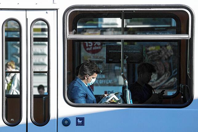 Keine Pflicht: Ein Mann mit Mundschutz liest am 19. Mai eine Zeitung in einer Tram an der Haltestelle Bellevue in der Stadt Zürich.
