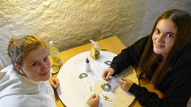 Neben dreißig Erwachsenen sind auch fünfzig Kinder und Jugendliche eifrig dabei, die Mosaike für den Erntedankschmuck zu legen. Lilli ...