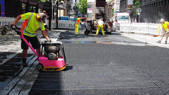 Prägeasphalt statt Platten wurde an der Kreuzung von Erzberger- und Hegaustraße verlegt. Hier prägt ein Mitarbeiter der Offenbacher ...