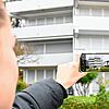 Eine Passantin fotografiert Wohnungen mit heruntergelassenen Jalousien. Gerade über die Wintermonate ein Merkmal von Zweitwohnungen in ...
