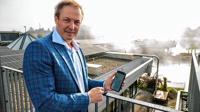 Geschäftsführer Dominik Keller kontrolliert auf dem Handy die Stromproduktion.