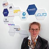 Christina Groll leitet das städtische Gründungszentrum &bdquo;Farm&ldquo;. Hinter ihr sind die Logos jener Firmen zu sehen, die von dort ...