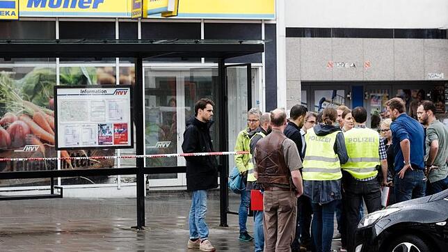 Polizeibeamte stehen in Hamburg vor einem Supermarkt, in dem am Nachmittag ein Mann einen Menschen tötete und vier verletzte.