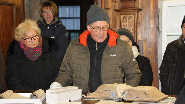 Archivar Walter Liehner (Mitte) hat das Buch aufgeschlagen, in dem sämtliche Dokumente aufgeführt sind, die das Archiv in Überlingen ...