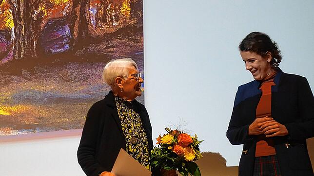 Bundestagsabgeordnete Lina Seitzl verleiht den ersten Preis an Wilma Keulertz. Im Hintergrund ein Ausschnitt aus ihrem Werk.