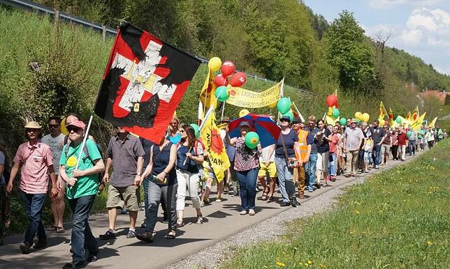 Mit Bannern marschieren die Demonstranten vom Gewerbepark Hochrhein auf dem Fahrradweg Richtung Rheinbrücke.