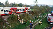 Um die große Höhe des Ausstiegs und den steilen Hang der Bahntrasse zu überwinden, haben die Feuerwehrleute Leitern mit improvisierten ...